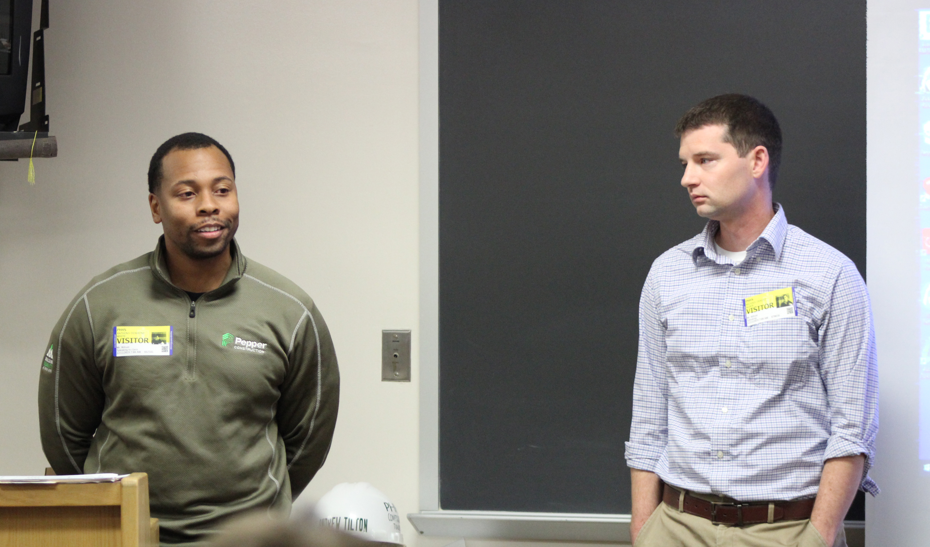 Anthony White and Mike Alder explaining construction career options to trade students