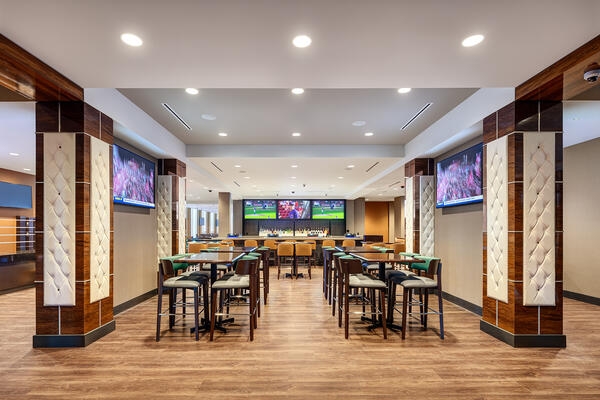 Custom millwork bar within the Grand Victoria Casino sportsbook featuring integrated gaming infrastructure and hospitality seating.