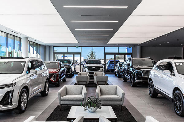 Luxury Cadillac showroom with custom metal panel finishes, specialty lighting, and premium customer experience spaces.