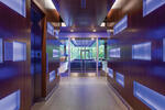 Elevator hallway entrance with a wood finish  leading to a glass door 