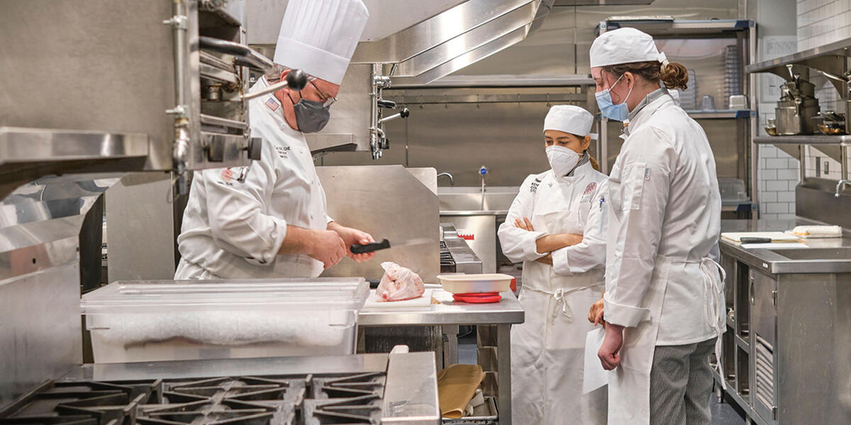 Kendall College Professor teaching students in student kitchen 